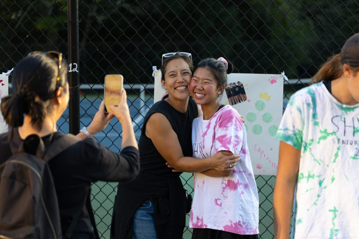 Minori Saito (11) poses with her mom in front of her senior poster. Out of all the seniors, she has been on the varsity team longer, since her freshman year. 