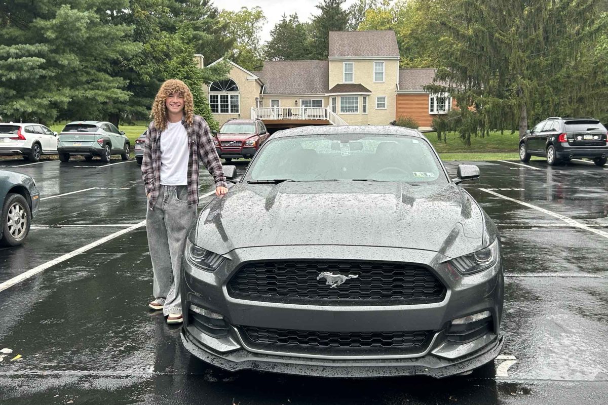 Senior Ben Mitchell poses in the rain with his revamped grey 2017 Ford Mustang on September 17.
