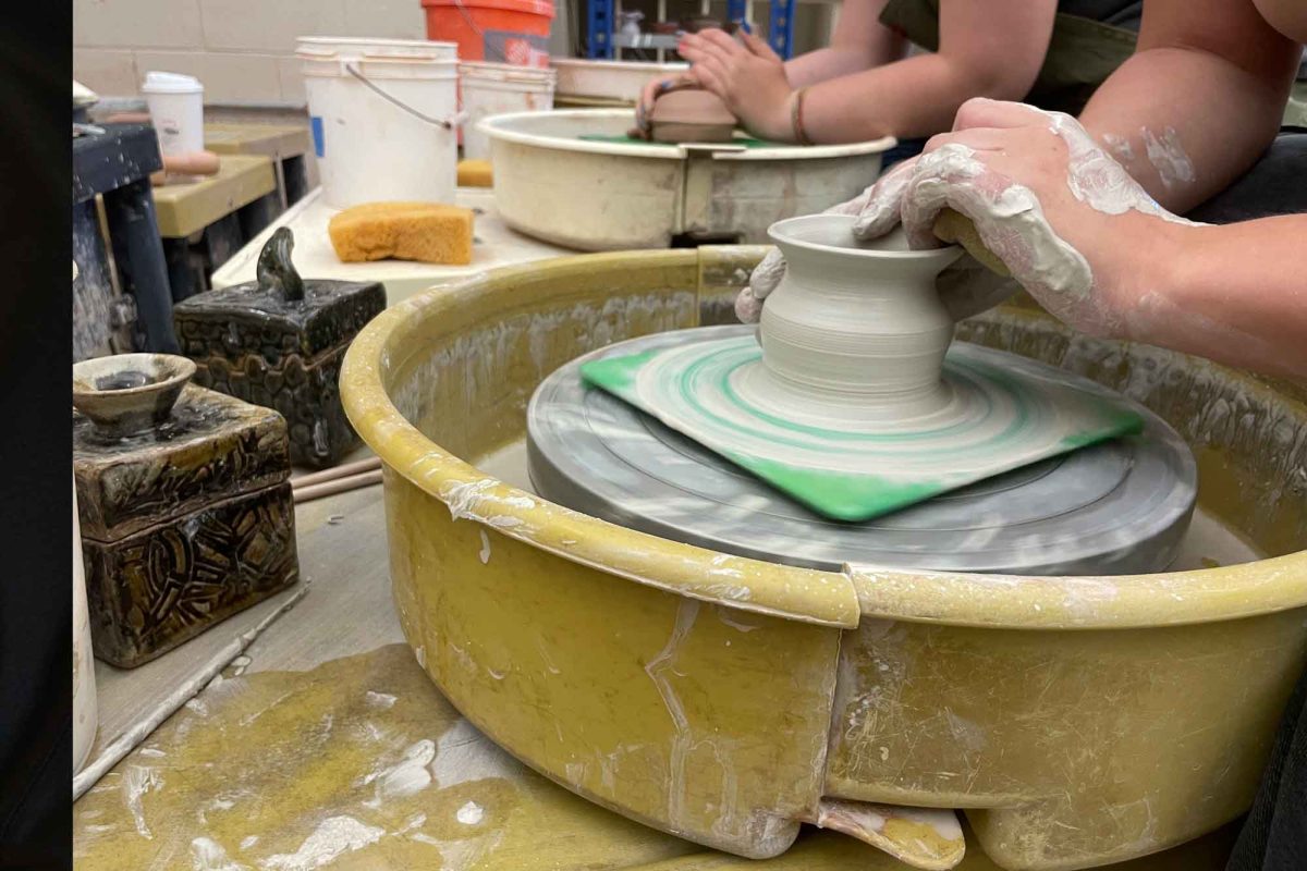 Badura takes in the cylinder and shapes it to be a vase.