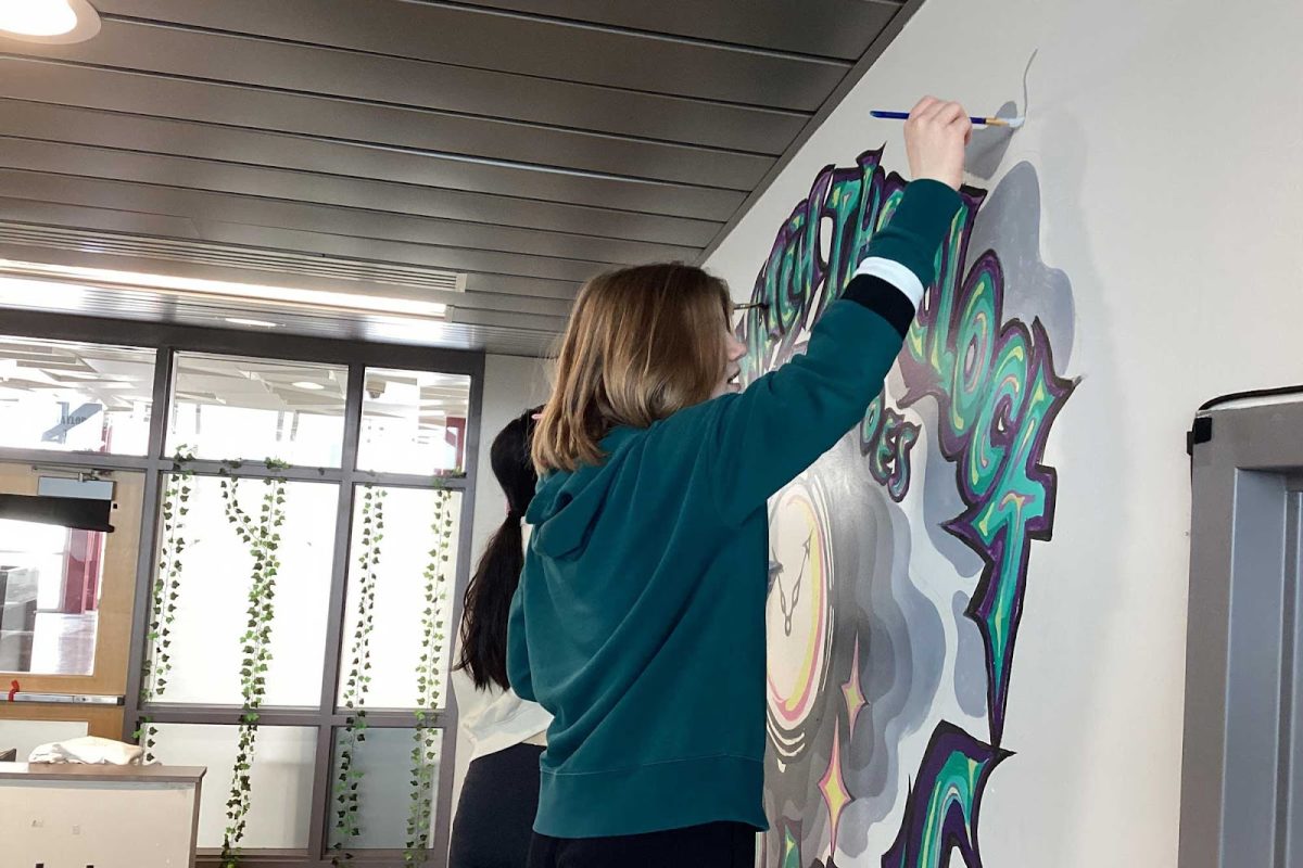 Evelyn Smith and Jolin Chen paint the mural located in SHMS. After they were given a topic to work with, Smith and Chen painted this in their 8th grade year, and made it their own. Provided by Mr. Masse.