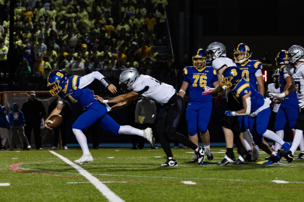 Luke Mulhern (12) pushes the opposing team's quarterback and causes him to fall  during a game against the Springfield Cougars on October 24 at Stadium Field. Mulhern and the quarterback exchanged words after this play. 