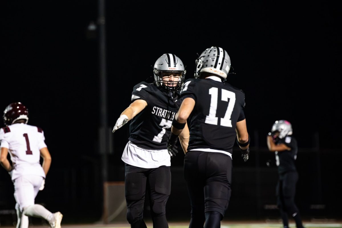 Cole Haly (11) and Quinn Kell (12) high five each other after a defensive play during the game against the Lower Merion Aces on Friday, October 17 at George L King field.