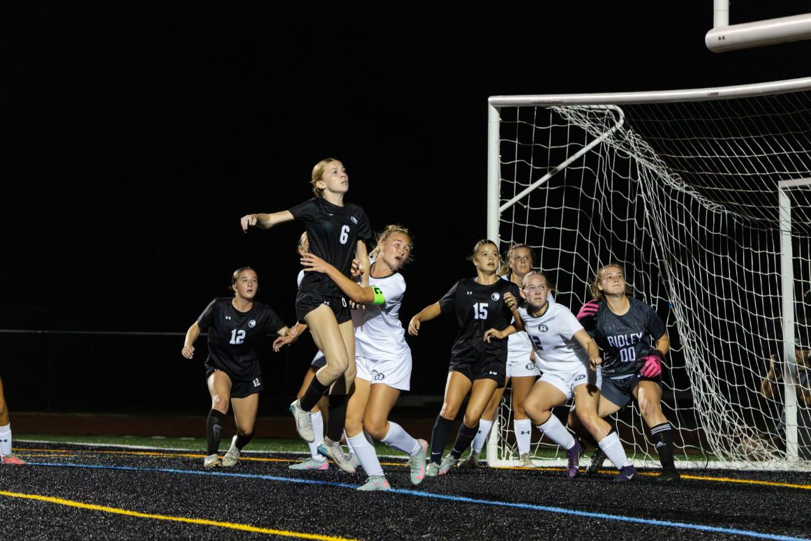Ava Hurwitz (11) jumps into the air in an attempt to hit a header into the goal as the ball comes towards her during a game against Ridley on September 30. Hurwitz scored two goals during the game. 
