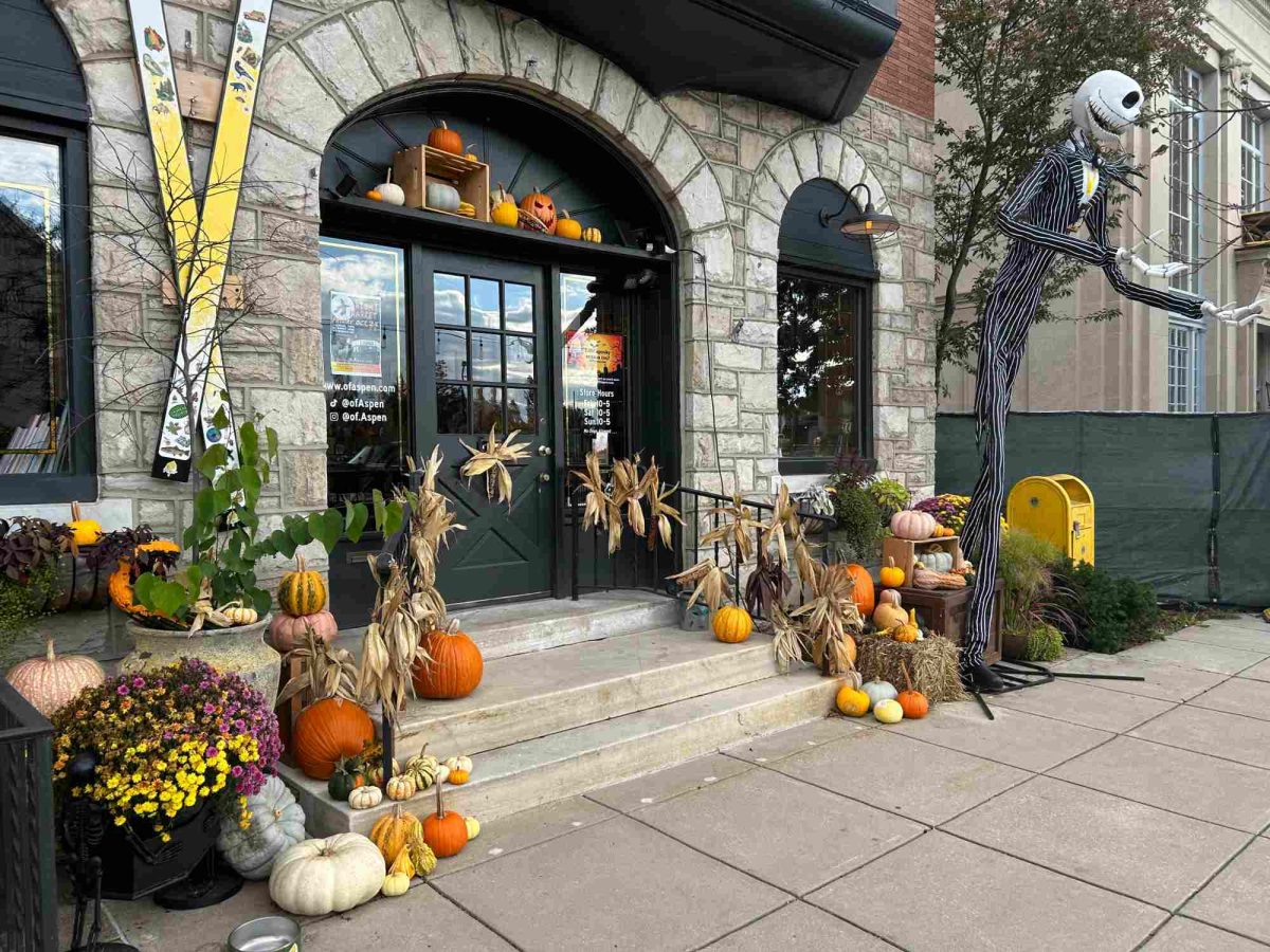 Decorated for Halloween, Of Aspen's storefront in Swarthmore, PA dons pumpkins, decorative corn, and bales of hay as a giant Jack Skellington greets visitors at the door.