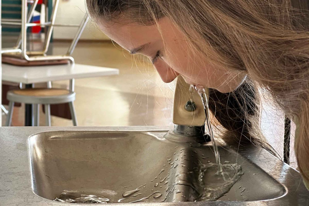 A student drinks from the fluoridated water fountain.