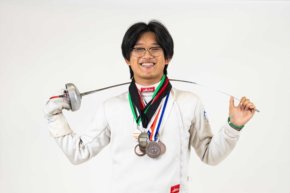 Jason Zhang (12) wears some of the medals he has won over his career.