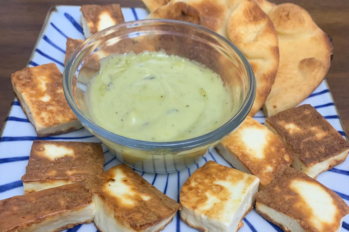 Fried paneer being served. Bread and curry dipping sauce are served alongside the paneer for a delicious meal.