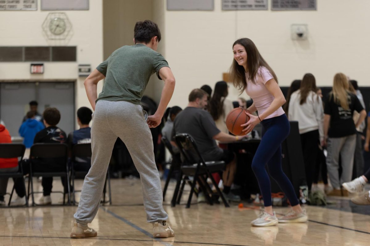 Julia Godo (11) looks for a way to get the ball past her opponent at the Chris King basketball tournament on Feb. 13. Students took a break from academics and competed with their friends.
