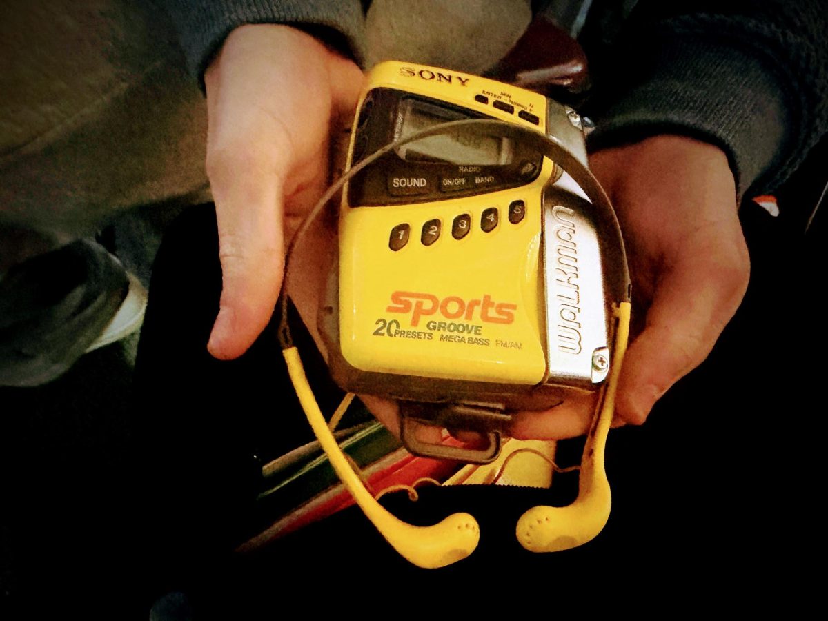 The author shows his Sony Walkman during a newspaper staff meeting on Feb. 3.