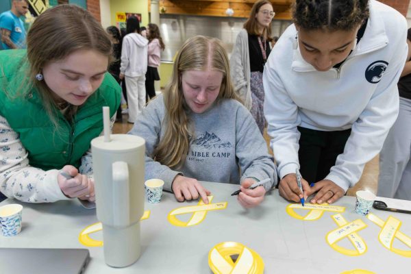 Savannah Neri (9), Zarah Bach (9), and Nadine Detsi (9) write positive messages on yellow ribbons for Wellness Wednesday on Feb. 18. 