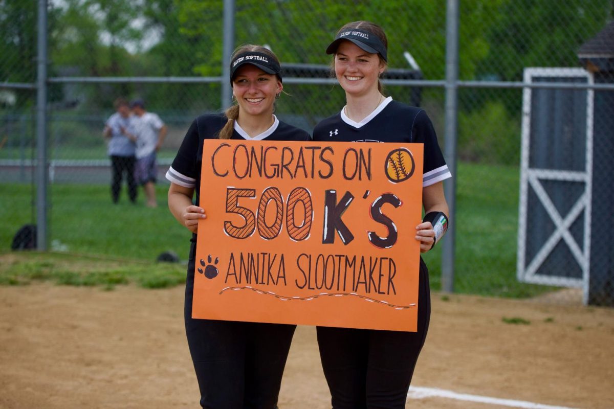 Avery Smith (12) and Annika Slootmaker (12) smile with a sign boasting Slootmaker's 500th strikeout of her career. Both players broke school records--Smith got her 100th hit on April 20, earning her more hits than anyone on Haven's softball and baseball teams. 