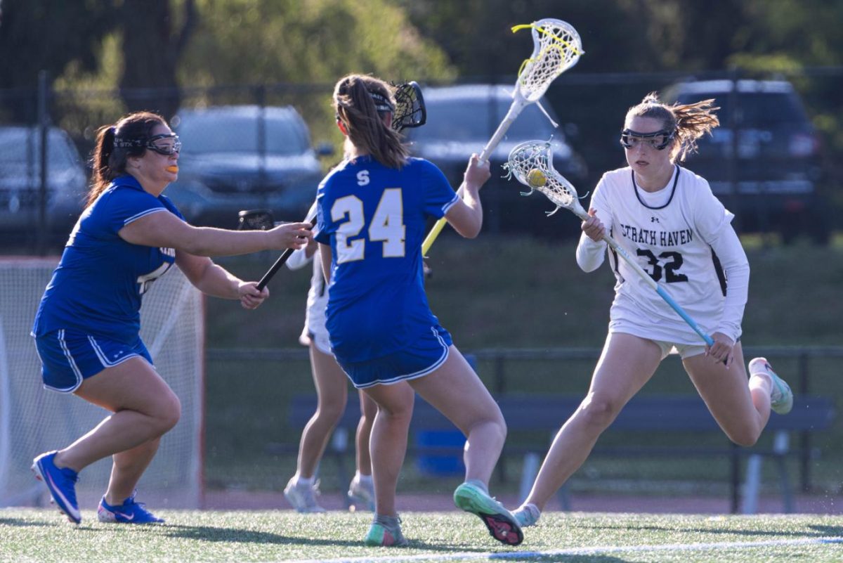 Katie Trout (12) carries the ball down the field, dodging Springfield players.