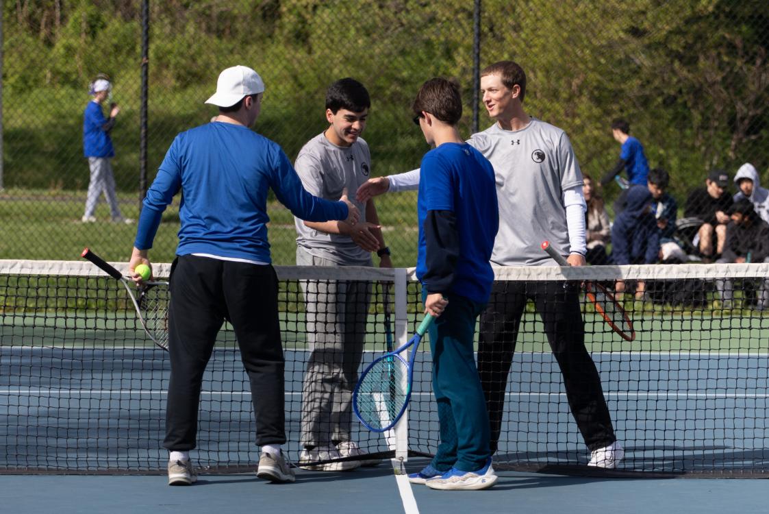 Doubles partners Ted Dudley (12) and Eddie Gebhart (12) shake hands with their Springfield opponents after a home match on April 20. The partners won their match 6-4 in the first set and 6-0 in the second.
