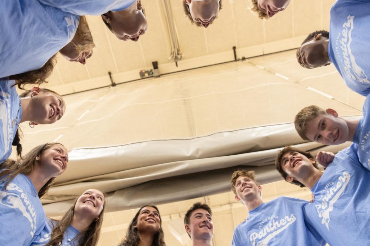 Student Council members gather in a group huddle after the opening and yearbook distribution rally on Friday, August 28 in the gymnasium. Student Council organized a free-throw contest and announcements about upcoming events.