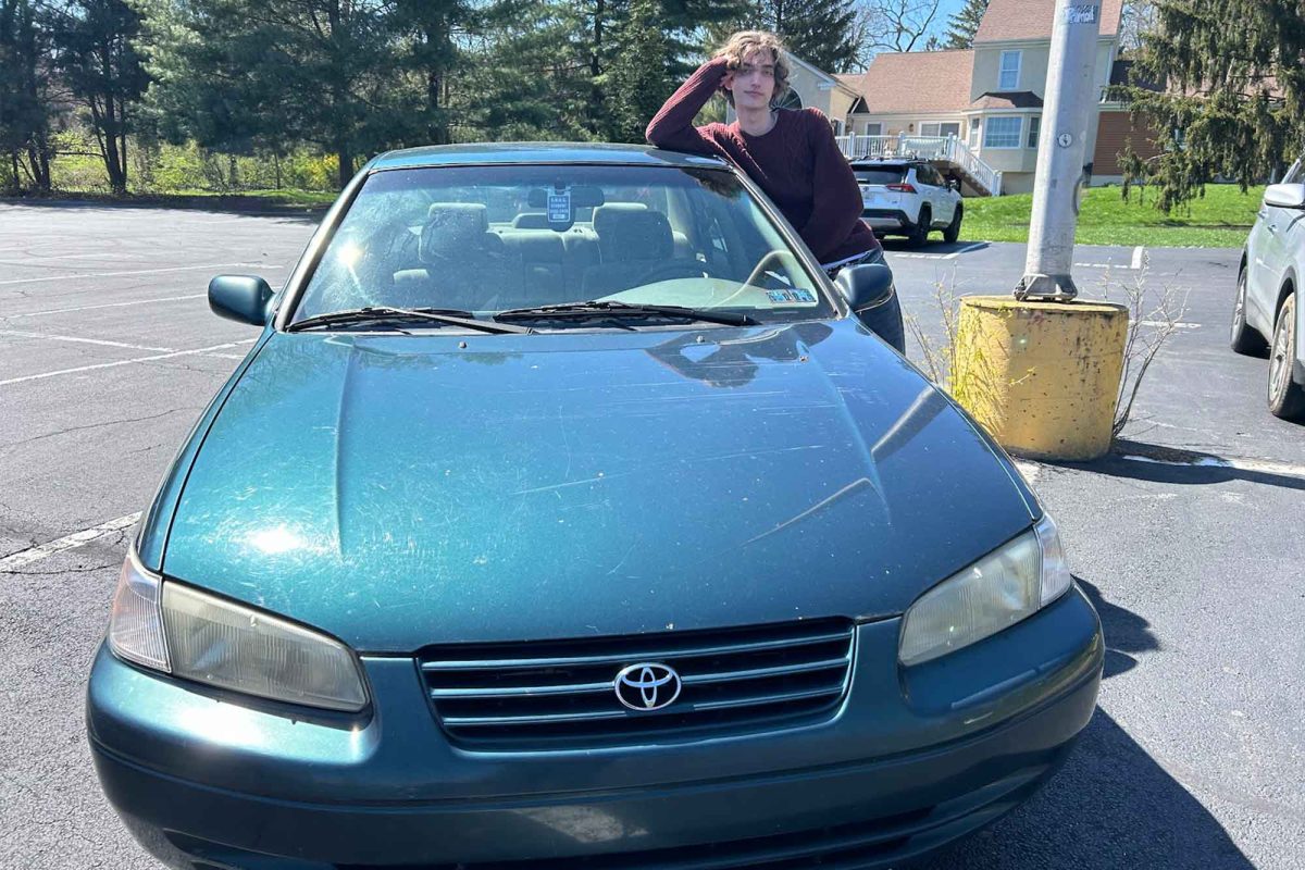 Senior Theo Berkman-Lamm poses alongside his 1997 Toyota Camry.