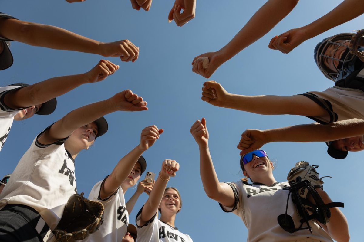 The varsity softball team chants during their pre-game huddle at the Division I playoff game against Phoenixville on May 18. The girls ended with a 14-7 record. “I think it was a really good season, especially [since] we went into the season with positions being moved around and losing a lot of important seniors from last year,” catcher Alyssa Bisordi (10) said.