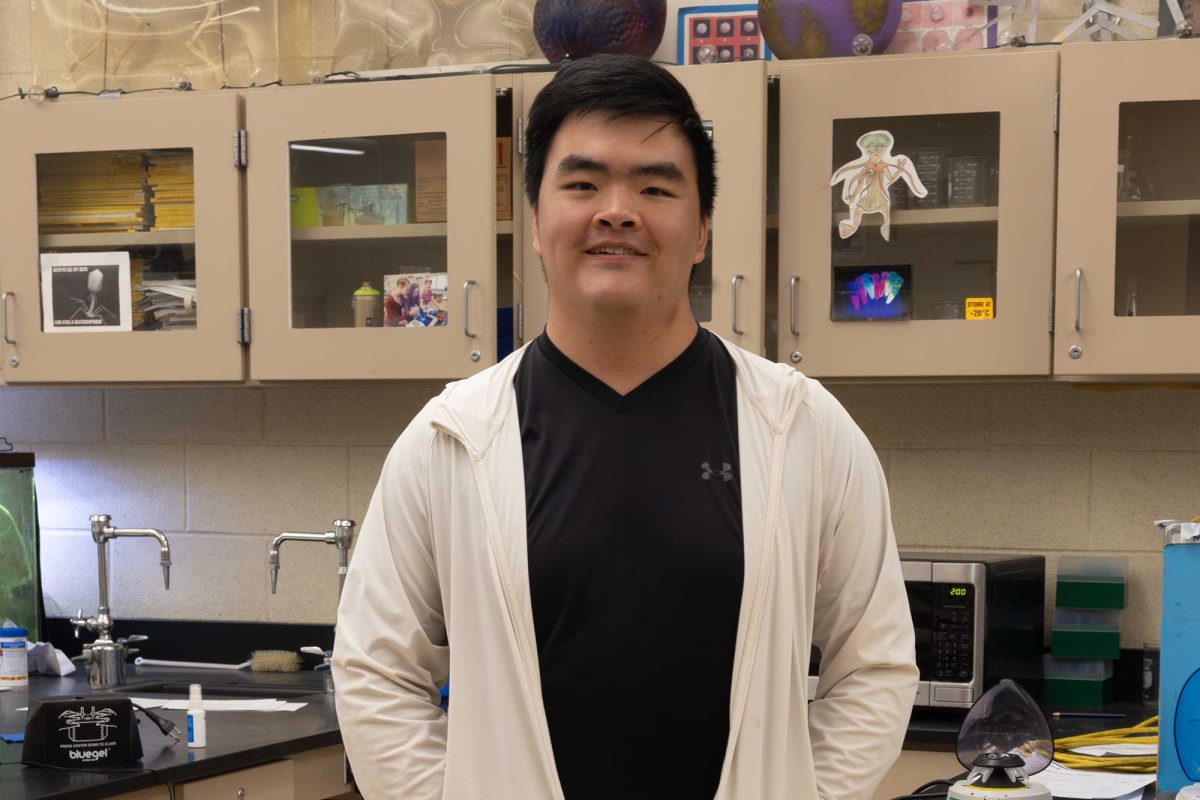 Ricky He (12) poses in the physics lab.